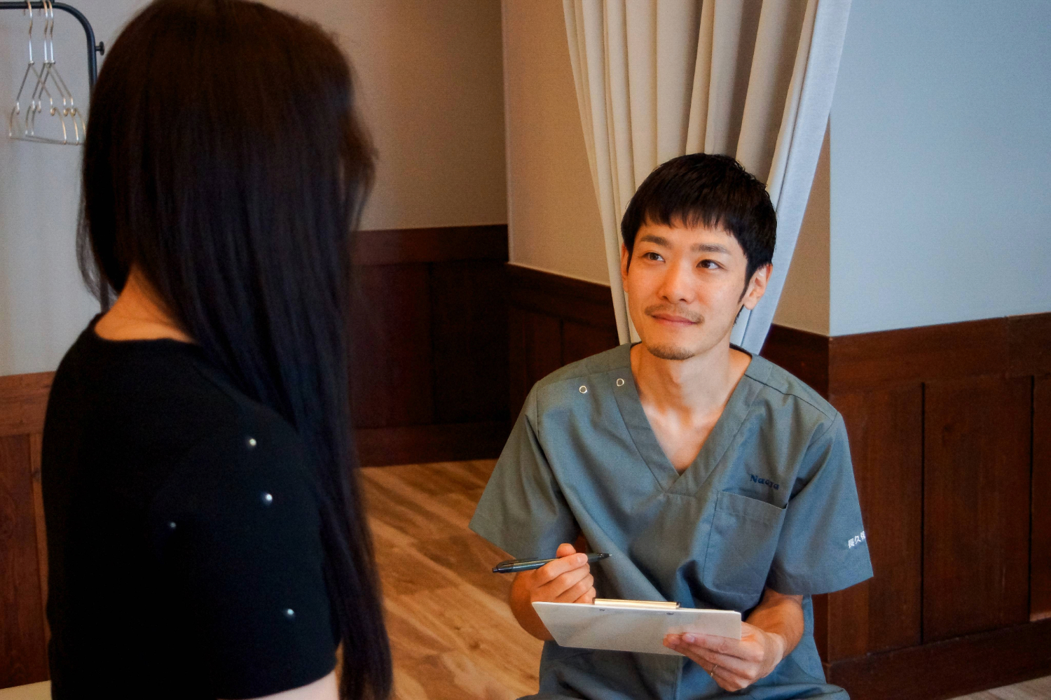 整体師が女性患者に問診している様子